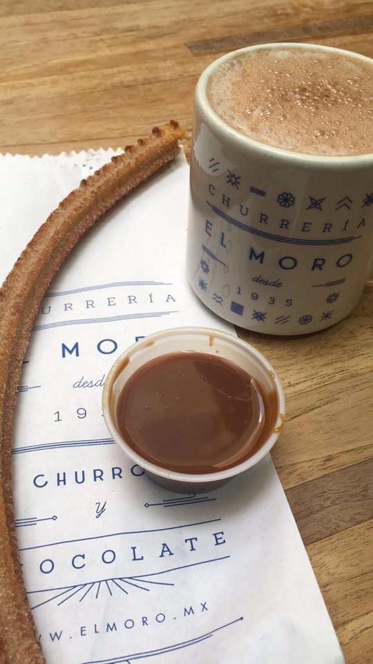 a fried churro with dip and a hot chocolate