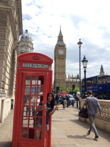 a photo of the historic red phone booths with big ben in the background