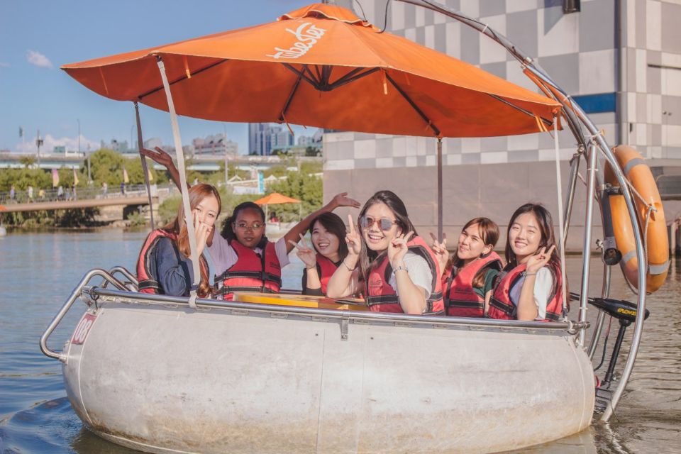 posing in a boat with an orange umbrella