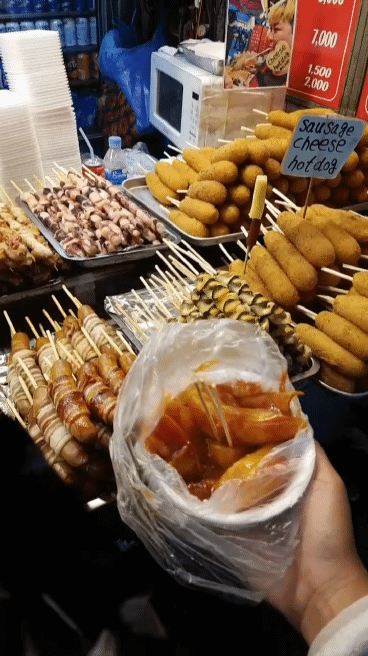 a myriad of various street foods are on display and being freshly prepared