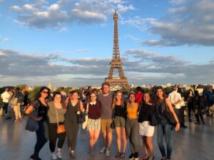 A group of friends standing in front of the Eiffel Tower in Paris, France.