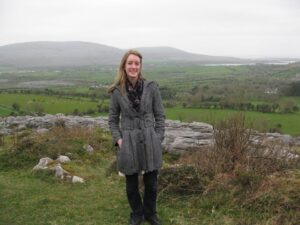 A women outside with hills and greenery in the background.