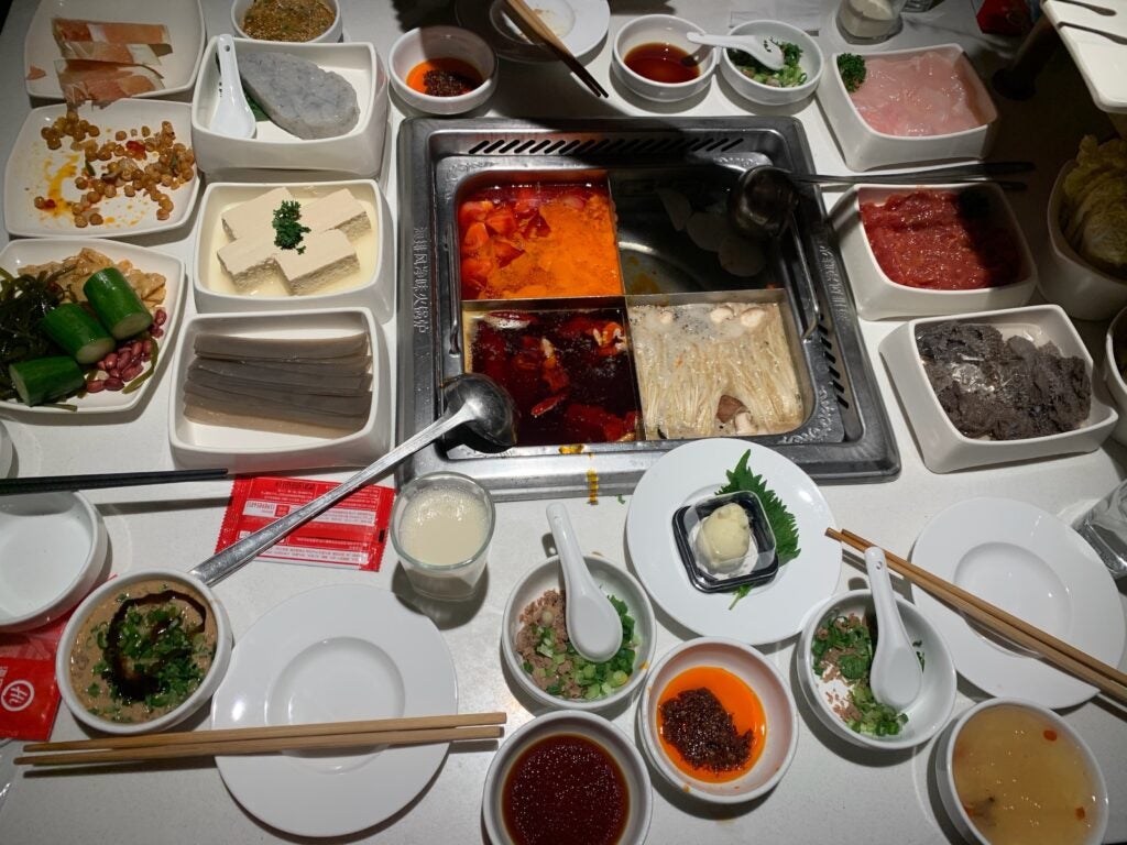 white table with several trays and plates of various foods