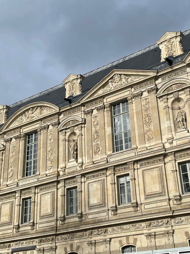 side view of building with windows and ornate carvings during daytime