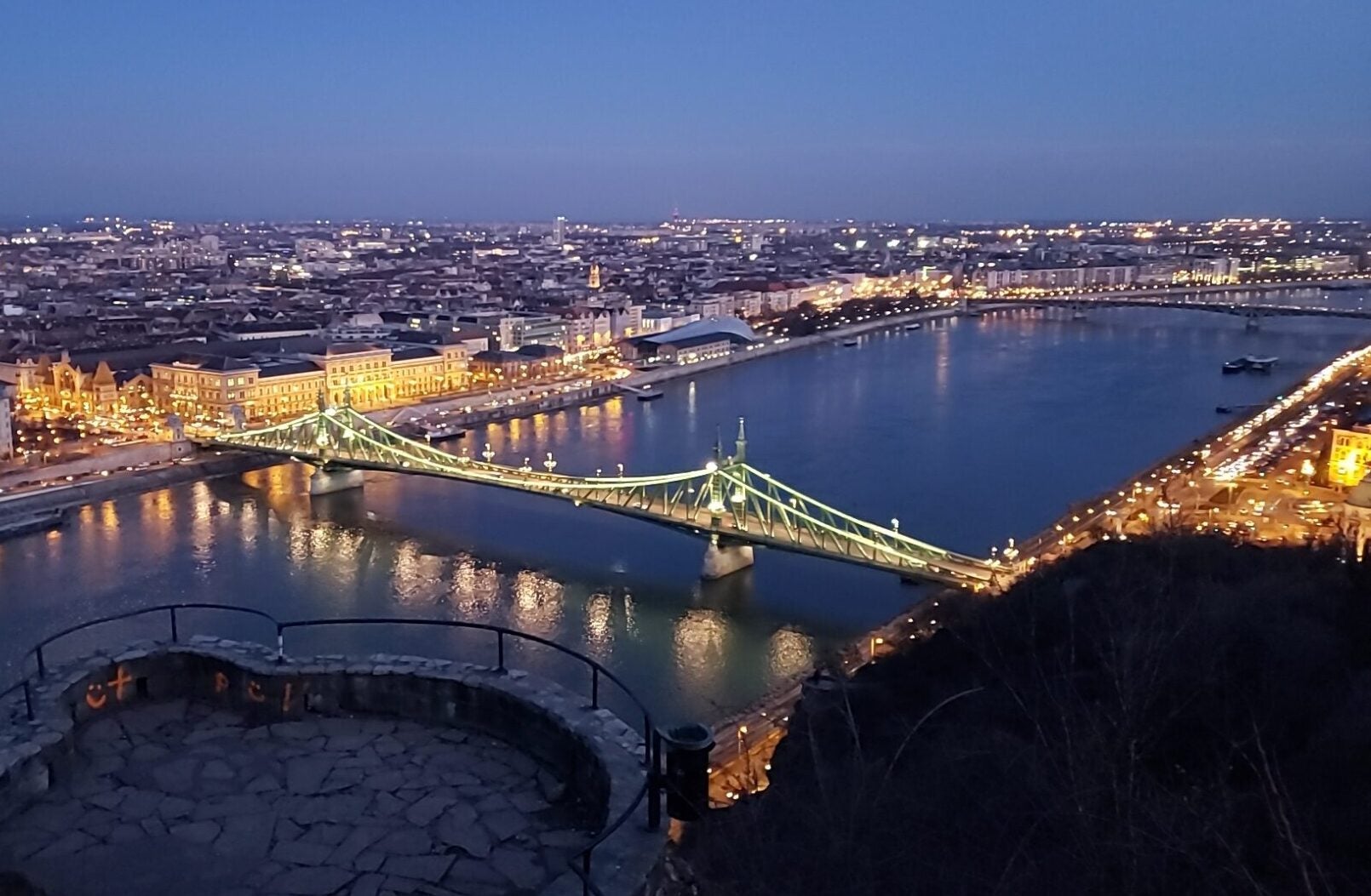 nighttime view of bridge, river and city