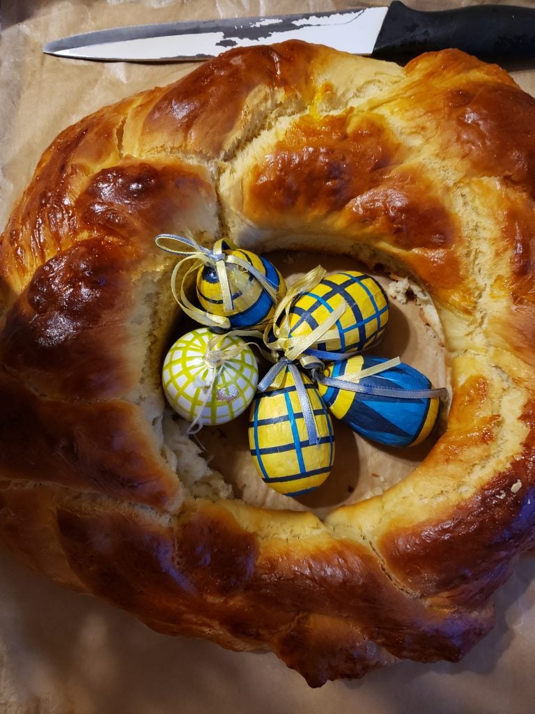 braided bread loaf with small colourful wrapped eggs on top