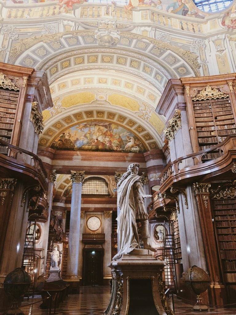 interior of historic library with domed ceilings and ornate pillars and sculptures