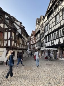 people walk near black and white buildings on cobbled street way during daytime