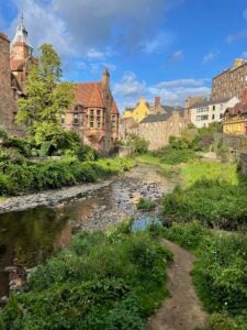 Historic Dean Village and surrounding creek and wildlife, against a blue sky.