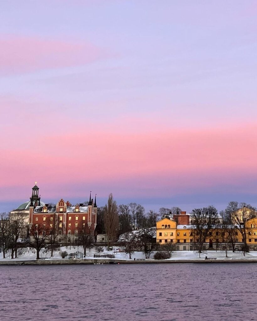 A vibrant, pink and purple sunset over the city in the distance