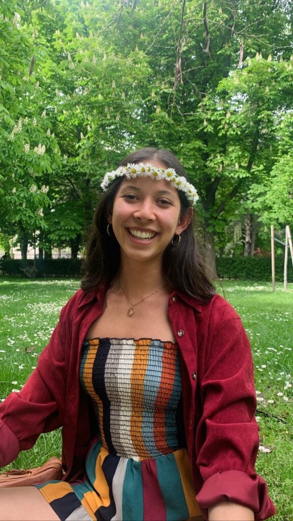 Erin smiles in a park, wearing a flower crown