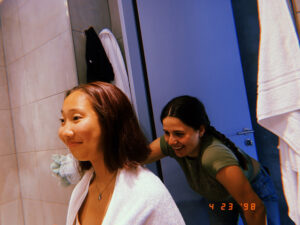 Jacki smiles as her friend cuts her hair in the bathroom
