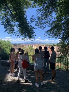 A group of students on an excursion to Segovia gaze at the town and mountains at a lookout point