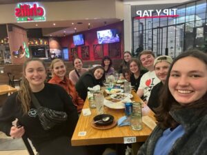 Global ambassador Jordan Matkin sitting with friends at a table at Chili's.