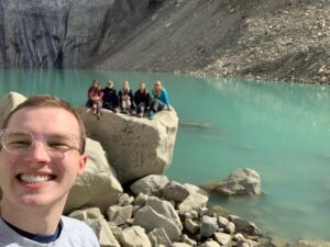 Global ambassador Jordan Matkin taking a selfie with friends in front of glacier lake in Torres del Paine, Chile.