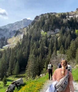 Katie Mulry walking down trail with class in the Swiss Alps.