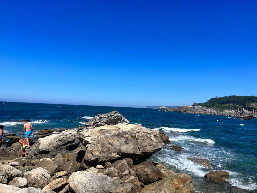 A view of the rocky coast of Spain. The deep blue water and sky compete for intensity.