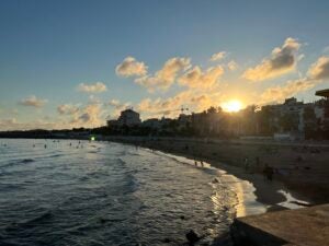 A gorgeous Spanish beachtown at sunset. The sun is setting just above the tops of the buildings.