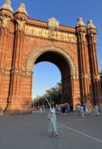 Vivian outstretches her arms in front of the Arc de Triumf in Barcelona