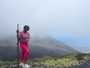 Morgan holds a stick taller than herself during a hike to a volcano