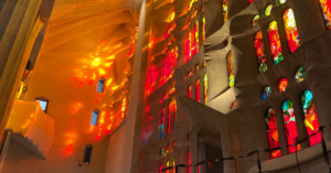 Red, orange and yellow light streams in through the painted glass windows at the Sagrada Familia