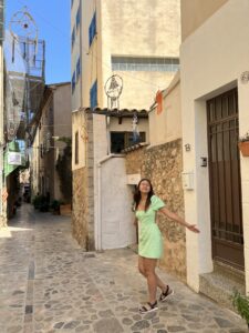 Vivian stands next to a cobbled stone street in Mallorca