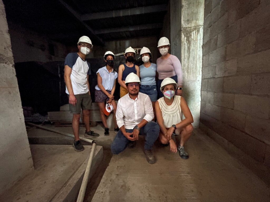 Group in masks and hard hats in dark cistern