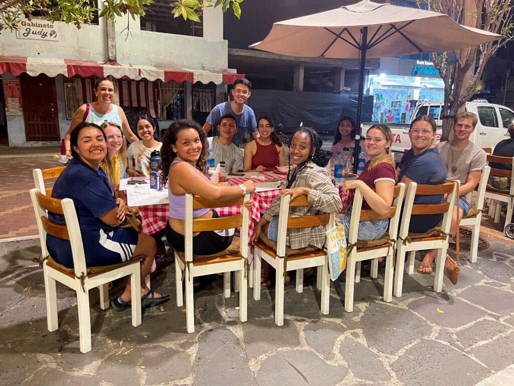 Group posing for photo while seated outside at restaurant