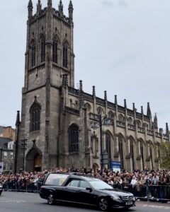 A Hearst carrying the Queen's casket passes a crowd of onlookers