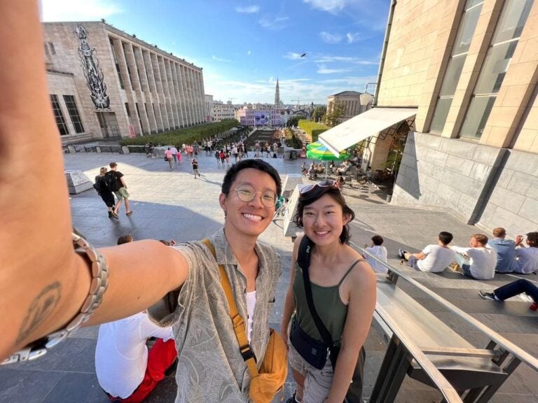 Carol and a childhood friend take a selfie in front of the Mont des Arts