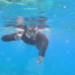 Man snorkeling doing hook 'em sign