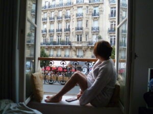 Elissa sits in the windowsill of her apartment