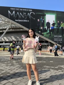 Nina poses in the concert venue, holding a light stick 