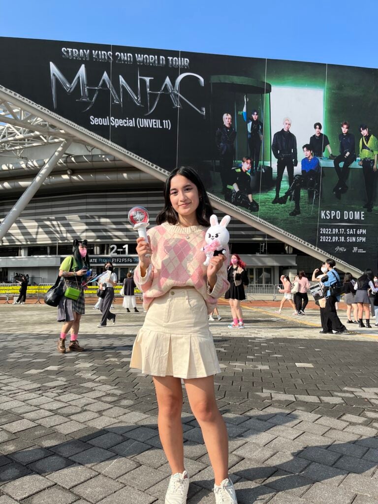 Nina poses in the concert venue, holding a light stick