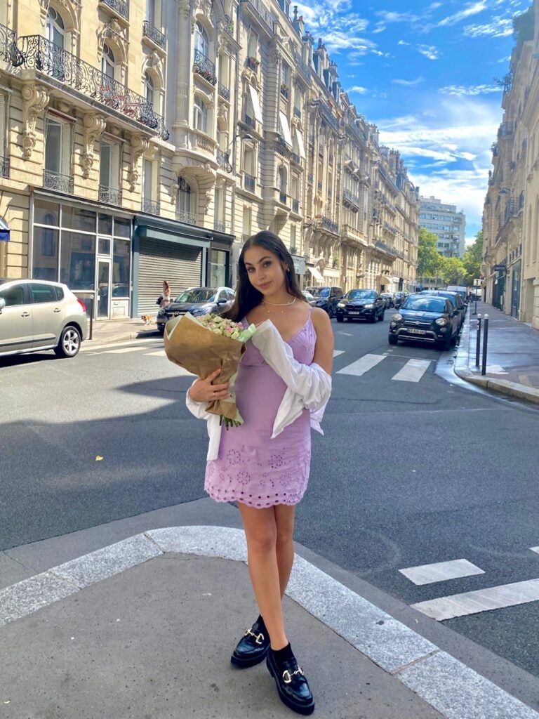 Amitai smiles while holding a bouqet of flowers from a famous shop
