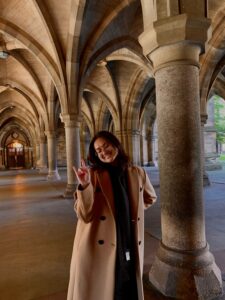 Gabby smiling at the University of Glasgow cloisters
