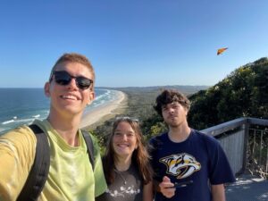 Students smile while hiking up to a lighthouse in Australia