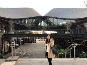 Sarah smiles in front of some modern architecture in London