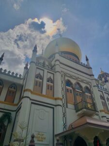 Looking up at a mosque with a gold dome in Singapore
