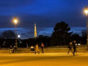 The Eiffel Tower is lit up golden at dusk