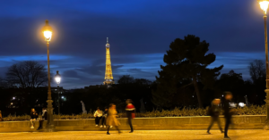 The Eiffel Tower is lit up golden at dusk