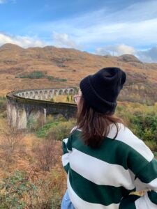 Gabby looks behind her at a viaduct