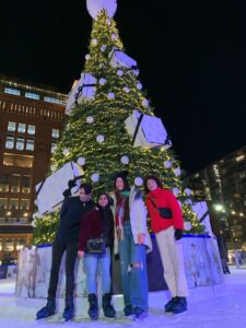 Tariq and friends pose for a picture in front of a Christmas tree while ice skating in London