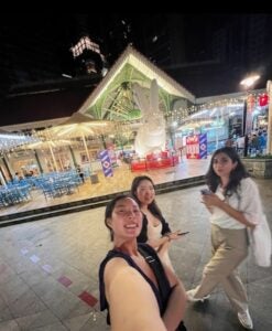 Selfie of three friends in front of a historic building in downtown Singapore.