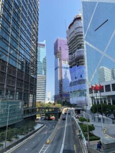 Tall glass buildings align a highway entrance ramp with few cars advancing in a central corridor of Hong Kong.