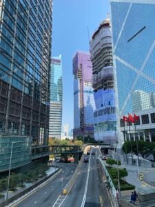 Tall glass buildings align a highway entrance ramp with few cars advancing in a central corridor of Hong Kong.