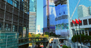 Tall glass buildings align a highway entrance ramp with few cars advancing in a central corridor of Hong Kong.