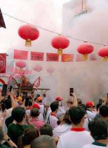 Smoke covers an outdoor market during a festival.