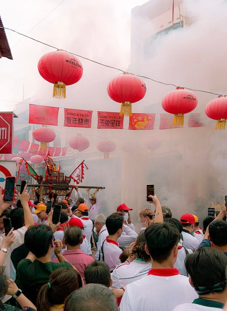 Smoke covers an outdoor market during a festival.