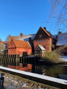 Brick building across a body of water on a clear, blue day.